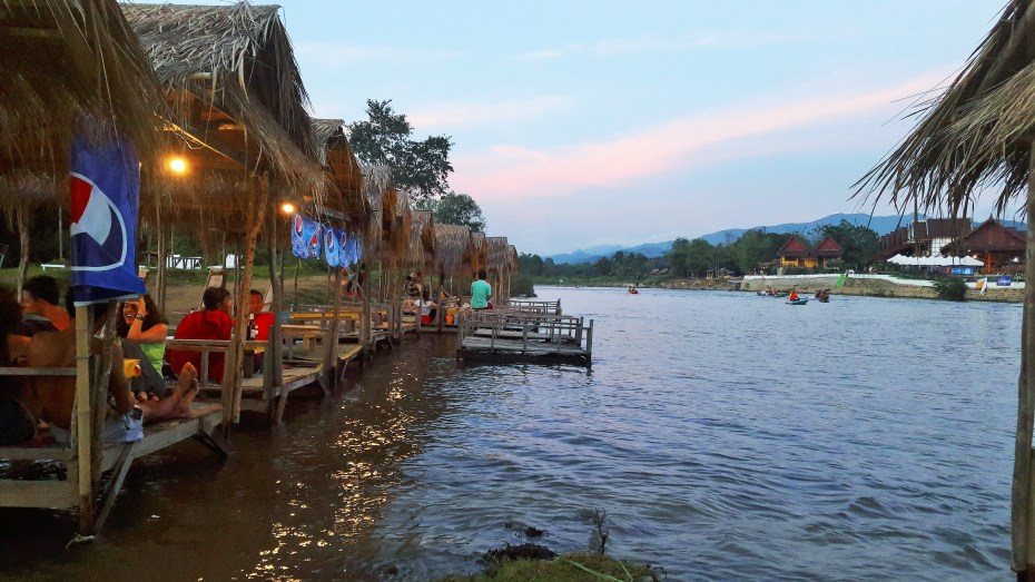 enjoying cool drinks by the river in Vang Vieng
