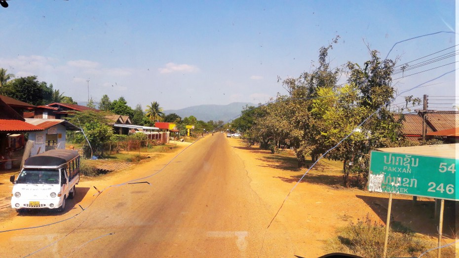 Our view out the broken bus window leading down the dusty road to Thakek